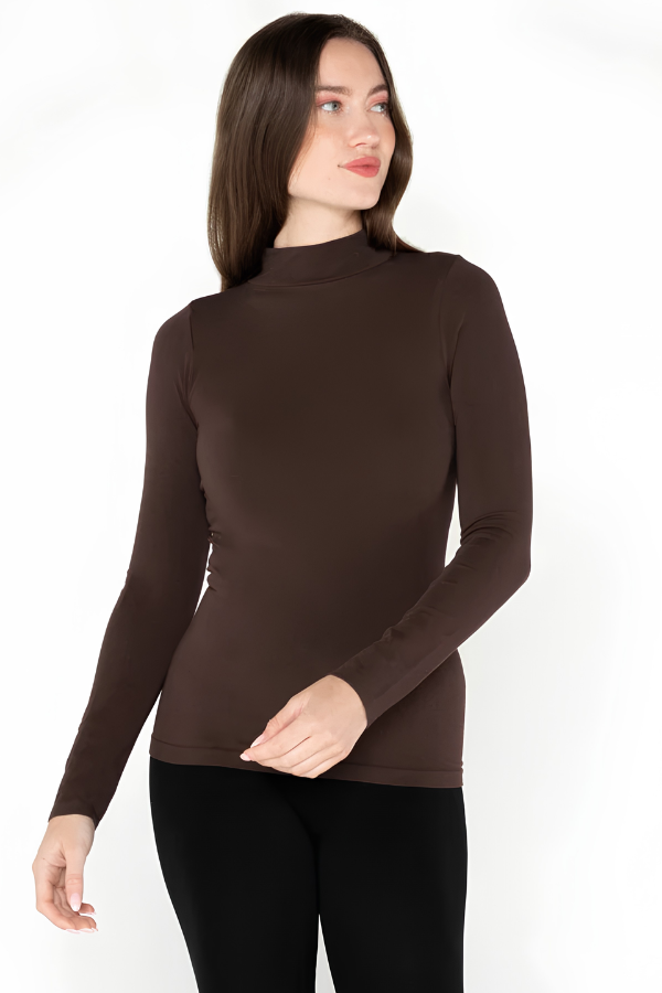 A woman modeling a dark brown mock neck long-sleeve top paired with black pants, photographed against a plain white studio background.
