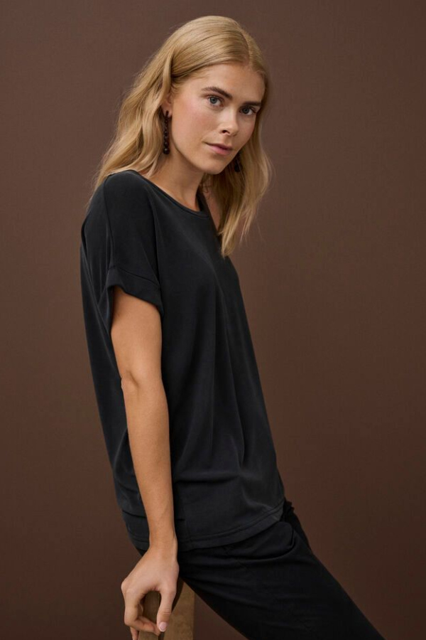 Woman wearing a black t-shirt against a brown background