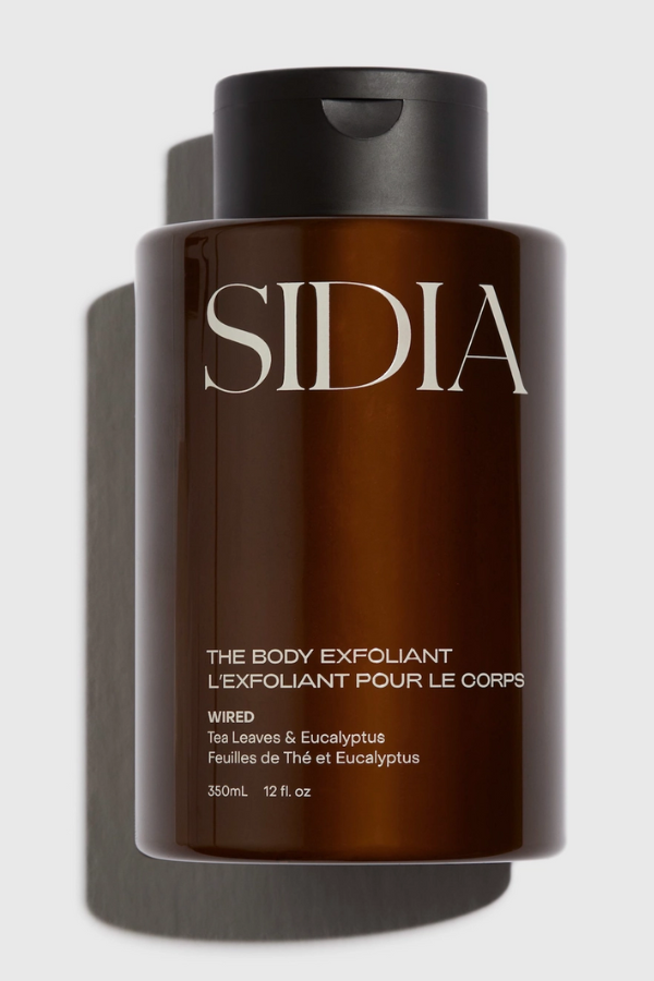 Brown bottle of Sidia body exfoliant on a light gray background