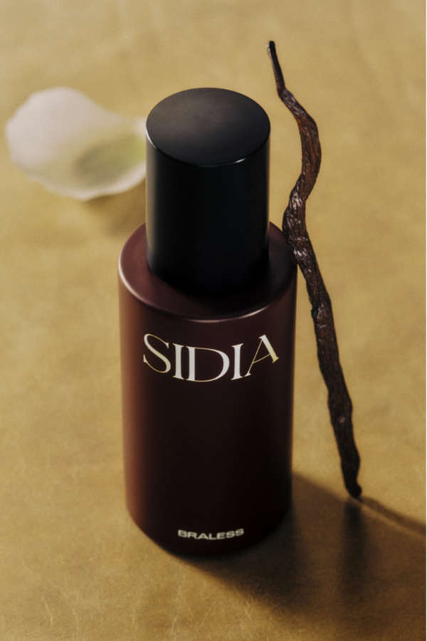 Sidia perfume bottle with a vanilla bean on a beige background