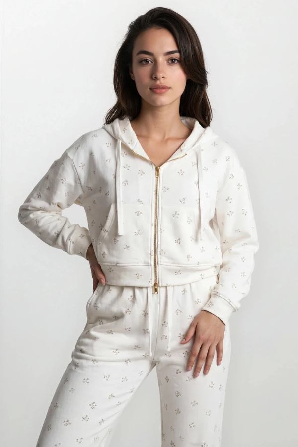Woman wearing a white zip-up hoodie and pants with star patterns on a white background